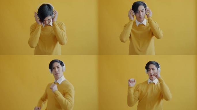 黄色背景上戴着耳机跳舞看着相机的快乐亚洲男人的肖像
