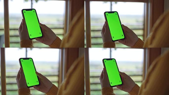 女士无法辨认的女人使用带有色度键绿屏的智能手机