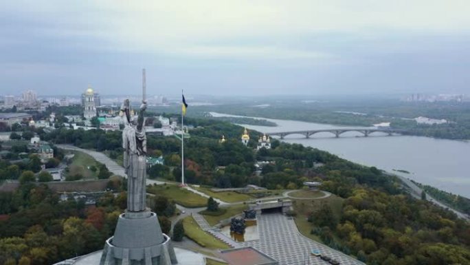 基辅著名祖国雕像和乌克兰国旗的后鸟瞰图，俯瞰美丽宁静的第聂伯全景。