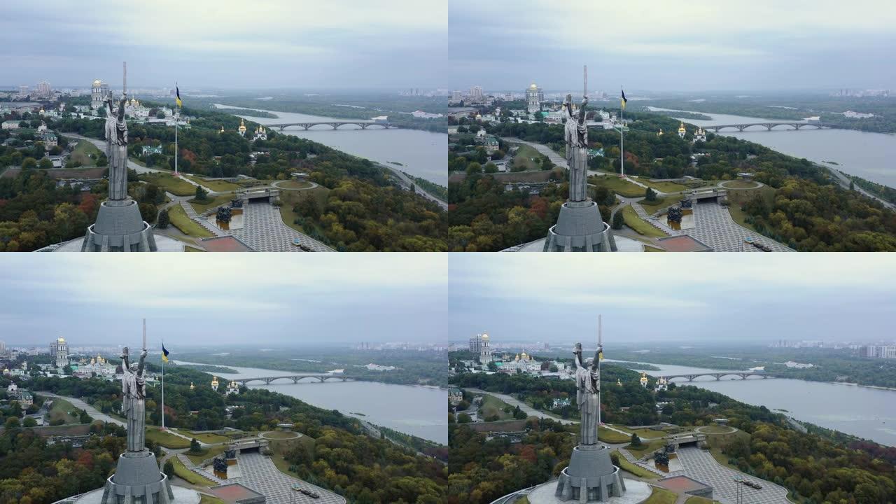 基辅著名祖国雕像和乌克兰国旗的后鸟瞰图，俯瞰美丽宁静的第聂伯全景。