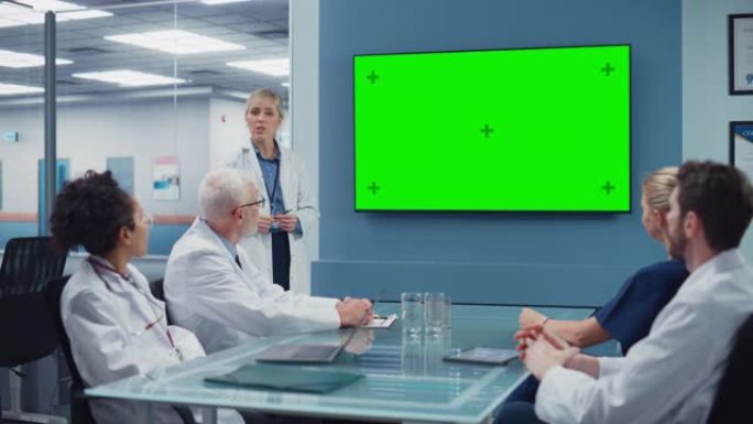 医院会议室: 女医生向医疗专业团队展示色键绿屏电视。研究科学家讨论患者治疗，药物和药物开发
