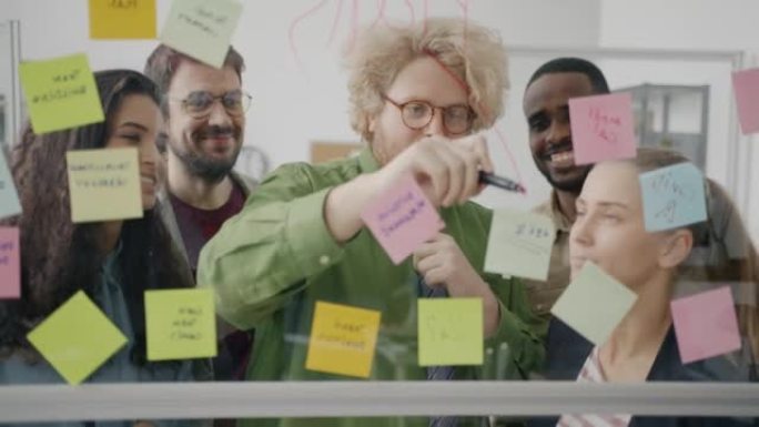 多元化的业务团队在办公室使用便签和玻璃板进行头脑风暴