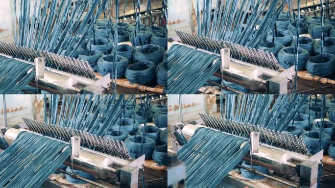 彩色纱线正在通过工厂机制解开。纺织厂生产设备。