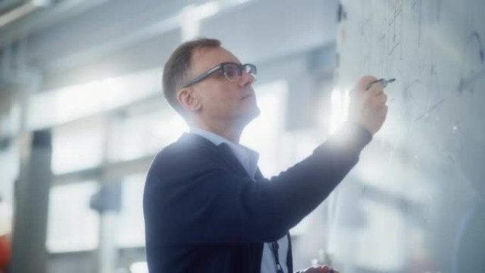 戴眼镜的有创造力的科学家男人在白板上说明工作方法并绘制统计图。科学、概念性和问题解决概念