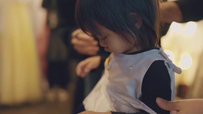 小女孩的特写镜头正在穿上韩服，这是一种传统的韩国服装。