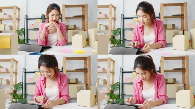 年轻的亚洲企业家女商人在库存上检查产品采购订单，并保存到家庭办公室的平板电脑工作。