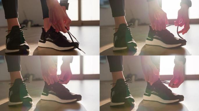 运动活跃的女人收紧运动鞋上的结，为晨跑做准备