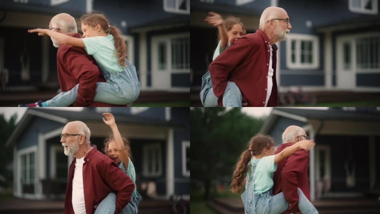 特写肖像，一个开朗的爷爷和他的孙女在户外度过，和快乐的年轻女孩玩耍。开朗的爷爷在房子前面的草坪上背着