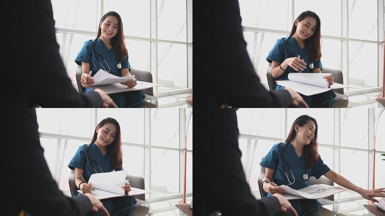 亚洲华裔女医生在办公室沙发上向一名女患者解释医疗报告