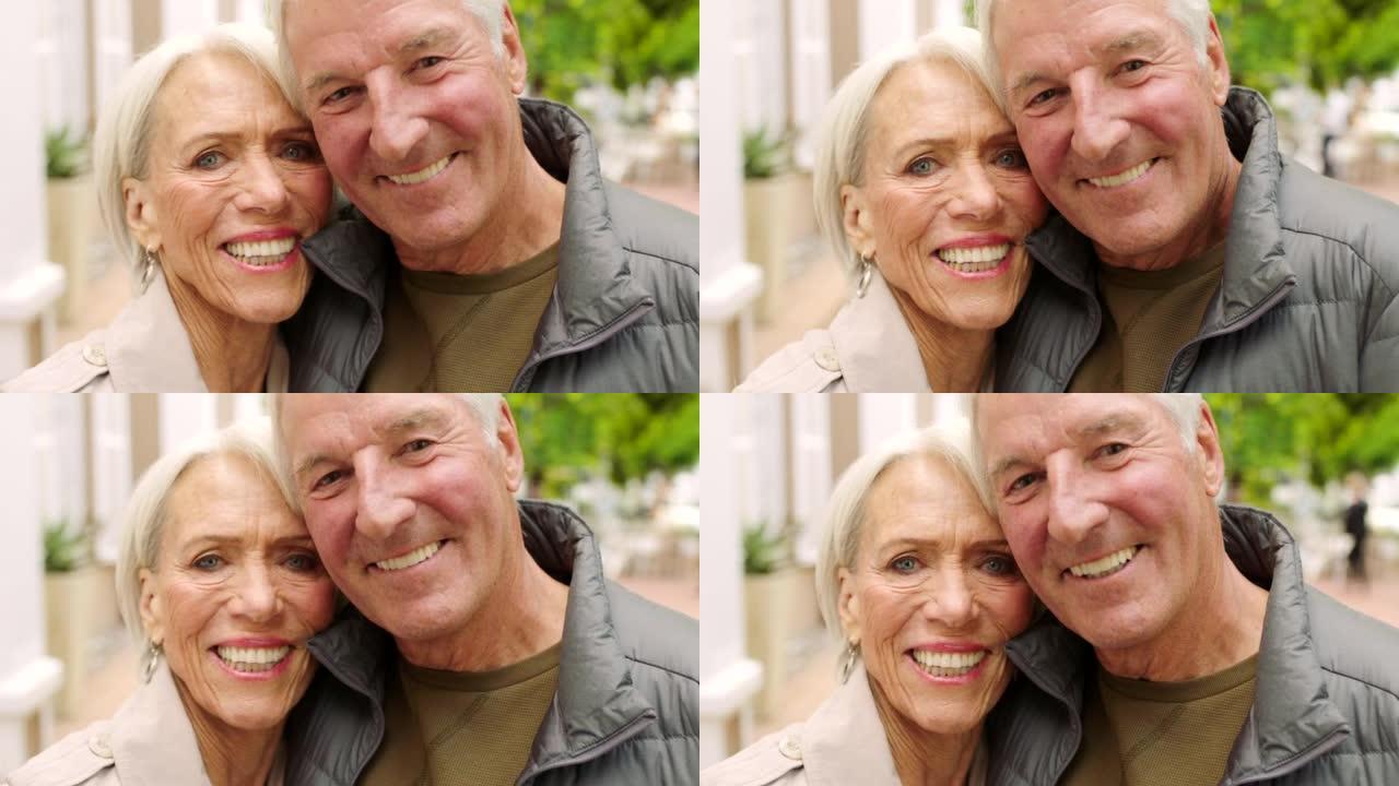 充满爱心的高级夫妇在城市中表现出爱心和爱心的肖像。退休丈夫拥抱妻子。一起庆祝他们的周年纪念日。成熟的