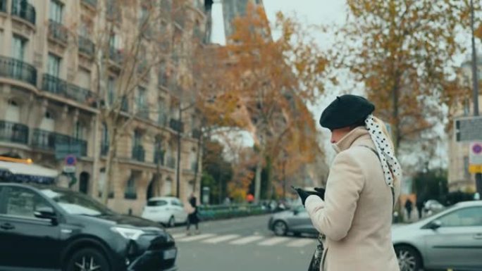 WS魅力四射的法国妇女在埃菲尔铁塔旁的街道上使用智能手机