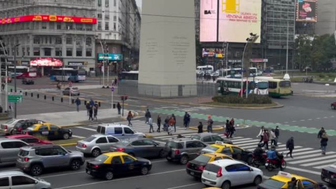 阿根廷首都布宜诺斯艾利斯中心方尖碑附近穿越朱利奥大道9号的人们的景色。4k分辨率。