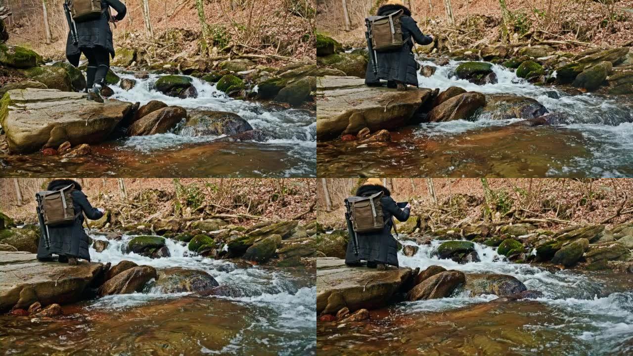 女人在岩石森林中流流的手机拍照