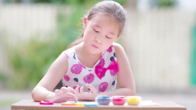 小女孩绘画与彩色水粉画在白纸上，儿童教育创造力发展与艺术