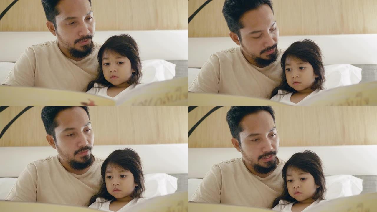 父亲和小女孩在床上读故事书。