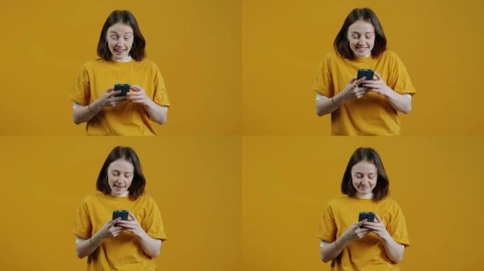 快乐的年轻女子的肖像收到指向智能手机的信息，然后发短信和微笑