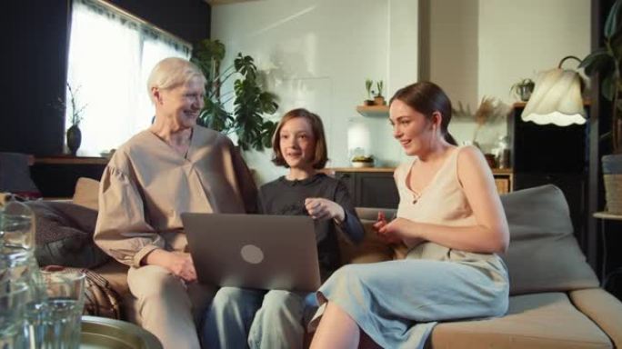 多代家庭。快乐兴奋的十几岁的女孩孩子在家里解释母亲和奶奶的笔记本电脑社交媒体。