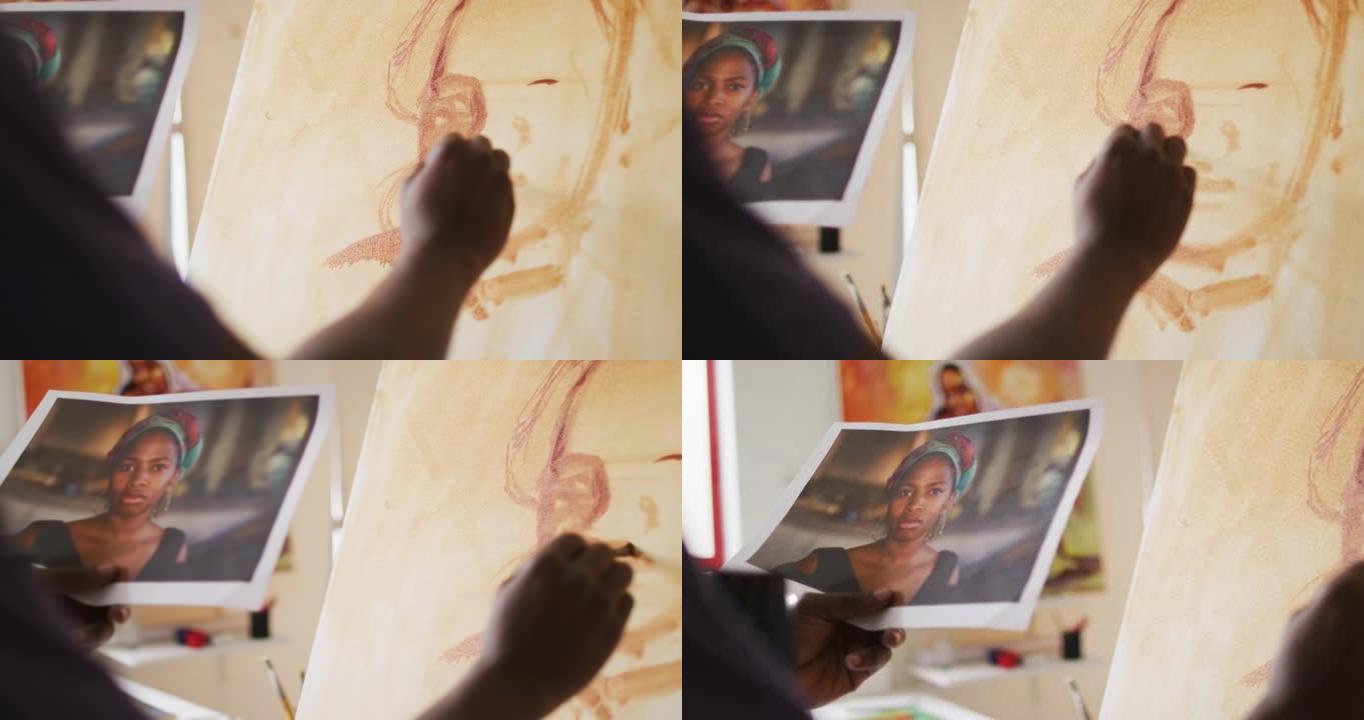 非裔美国男性画家在艺术家工作室的画布上绘画