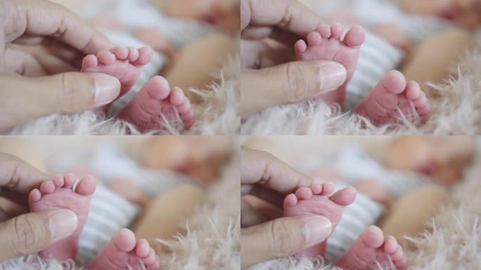 母亲手握和抚摸婴儿的小脚新生儿