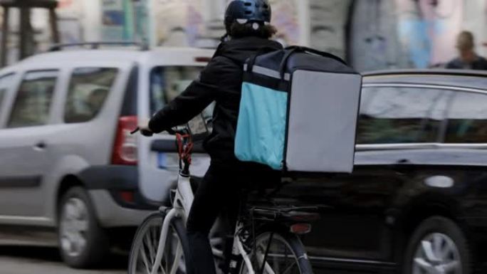 戴着医用口罩的快递员骑着自行车环游城市