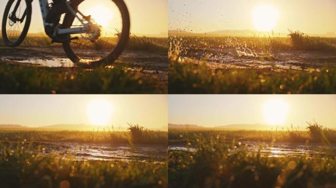 SLO MO无法识别的MTB骑自行车的人在日落时穿过乡村的泥泞