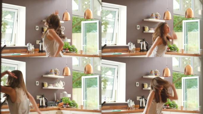 4k视频片段，一名年轻女子在厨房里跳舞
