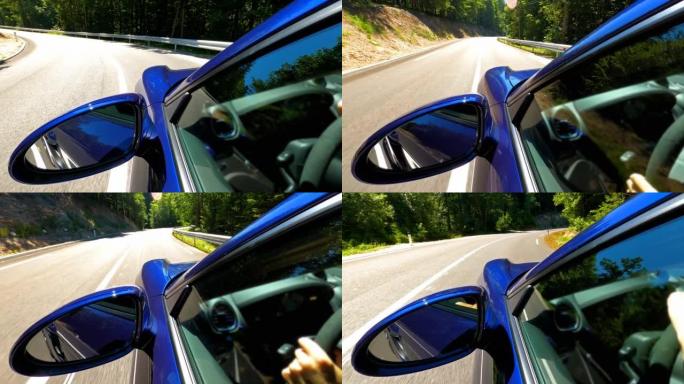 在美丽的晴天，驾驶一辆优雅豪华的蓝色跑车在风景如画的道路上行驶