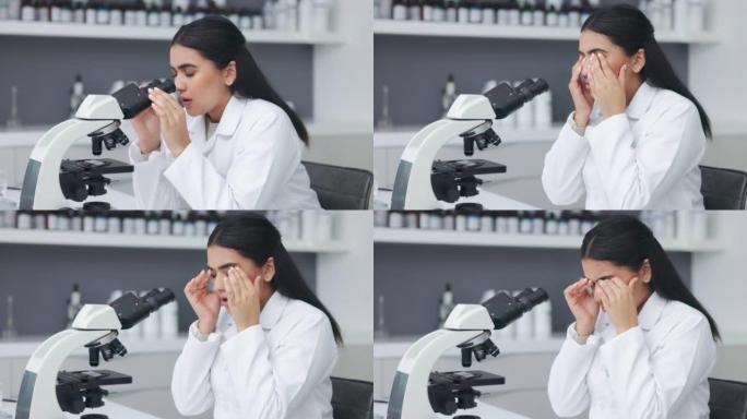 疲惫和疲惫的女人在实验室做研究时分析测试样本。压力很大的科学家通过显微镜观察，摩擦眼睛，在深夜工作时