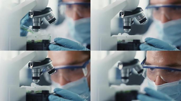 在显微镜下混合绿色化学液体的医用口罩和安全眼镜的男性科学家的宏观特写镜头。用技术设备在现代实验室工作