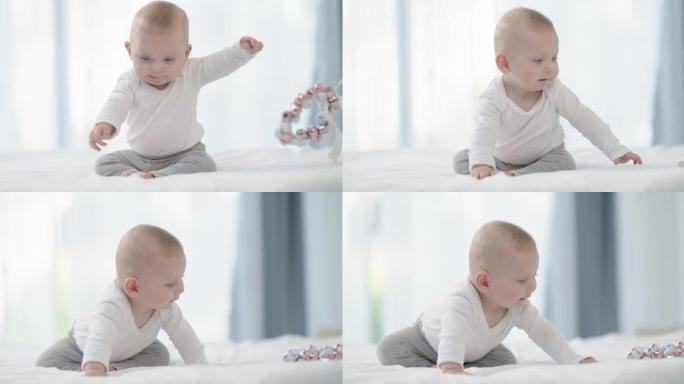 一个可爱的男婴在家里的床上玩玩具的4k视频片段
