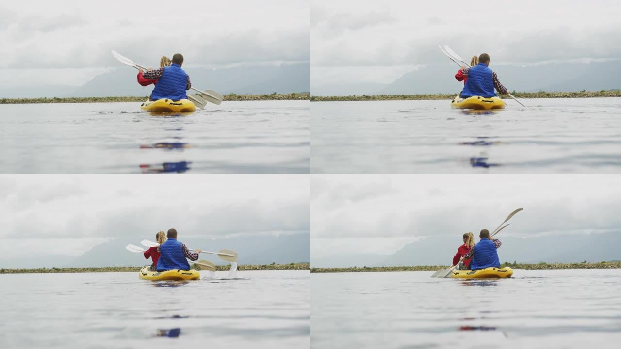 高加索夫妇在山上旅行时玩得很开心，一起在湖上划皮艇