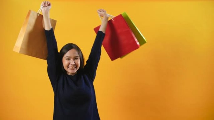 女人展示购物袋并感到快乐，购物狂