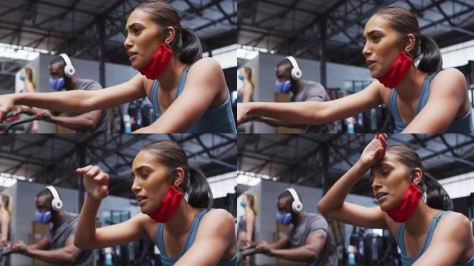 混血女子戴着降低的面罩在健身房锻炼