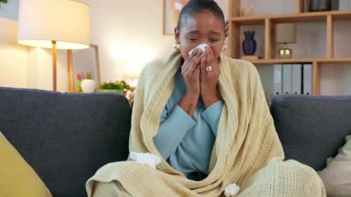 生病的女人坐在家里的沙发上患有covid乏力。身体不适的女性请一天假从严重的流感中恢复过来。女士因感