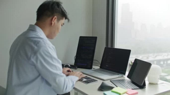 男人在办公室的笔记本电脑上编码