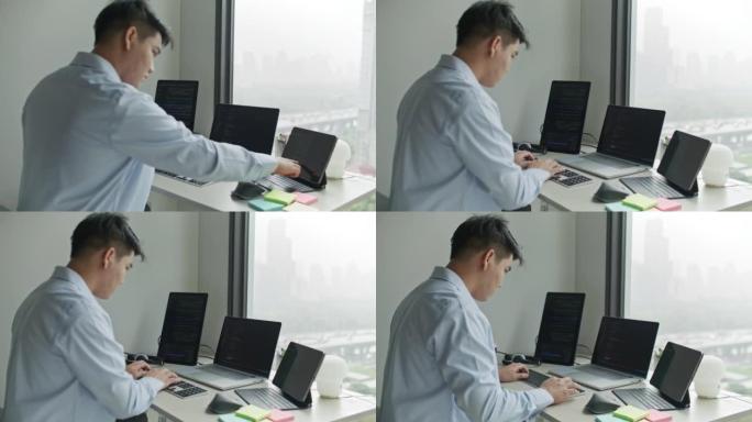 男人在办公室的笔记本电脑上编码