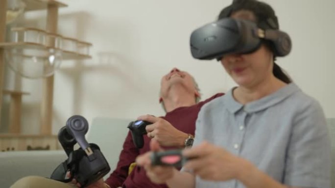 亚洲夫妇老人很乐意玩戴虚拟眼镜的电子游戏。