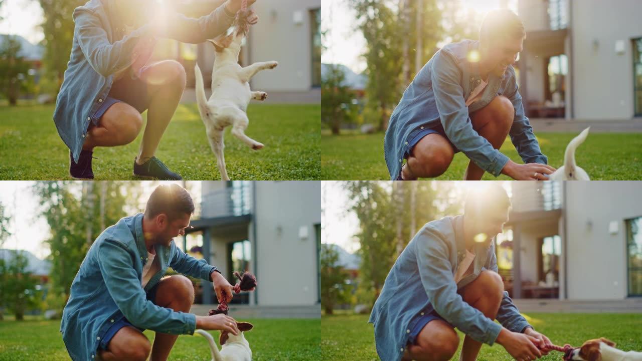 男人和他的杰克罗素梗狗在户外玩耍。他宠物，火车，用最喜欢的玩具戏弄他的小狗。田园诗般的避暑别墅。黄金