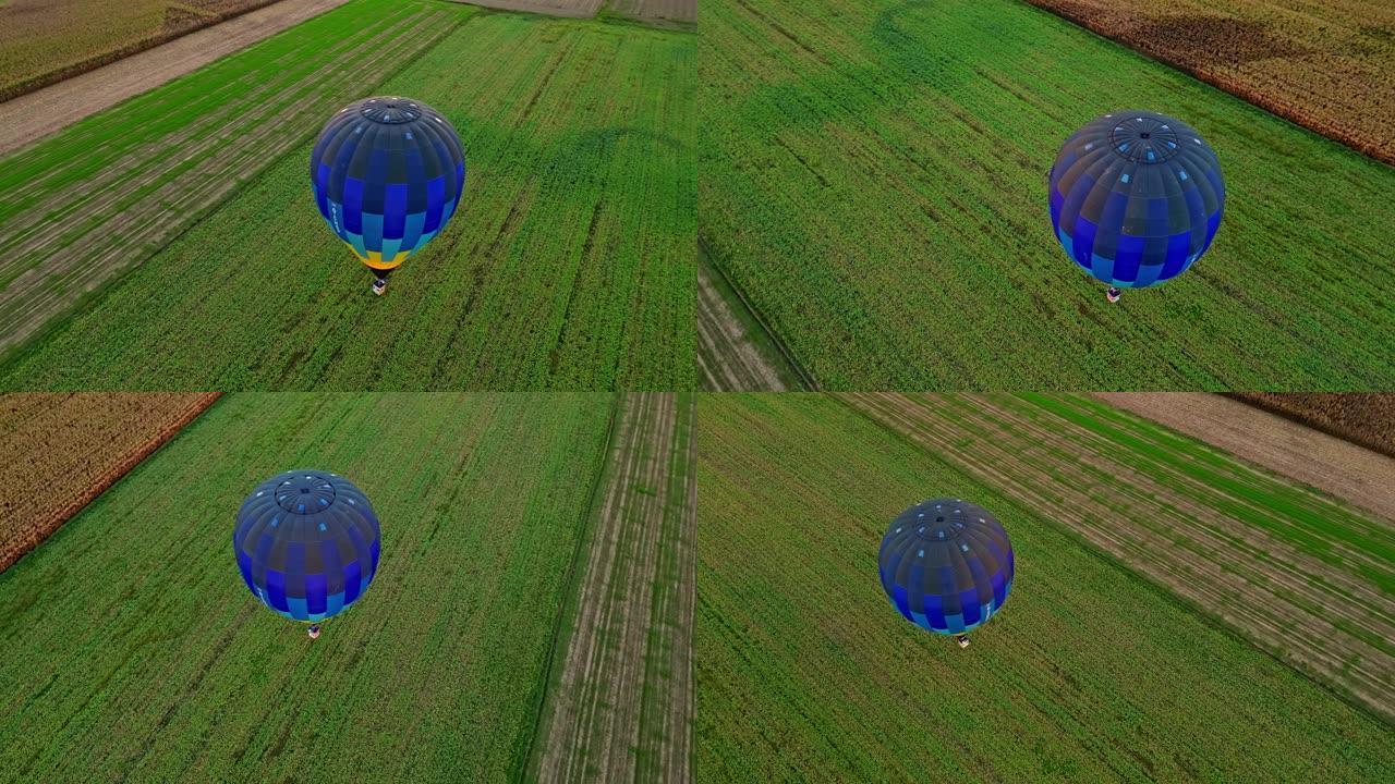 无人机的观点蓝色热气球飞越乡村田野