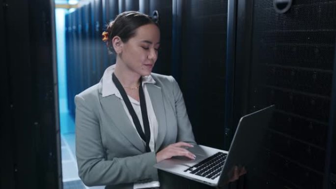 4k视频片段，一名年轻女子在服务器室工作时使用笔记本电脑