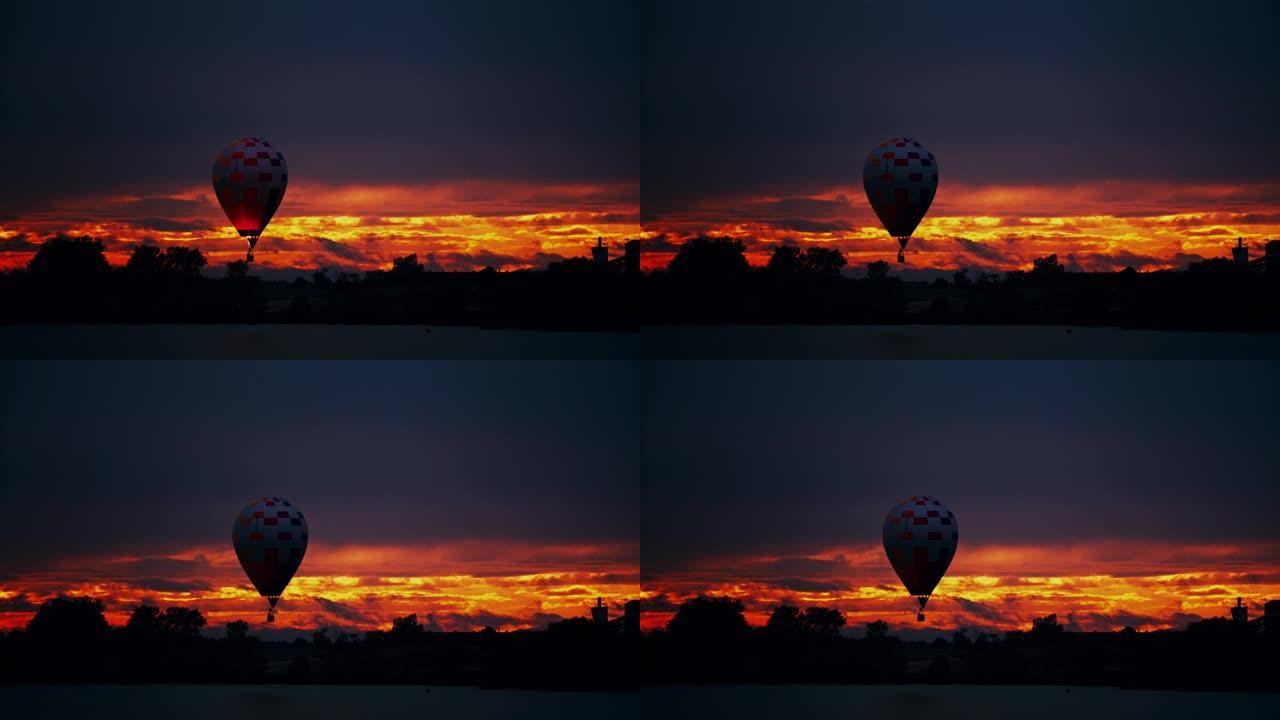 剪影的热气球在黄昏时在戏剧性的天空中飞行