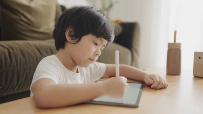 男婴在家用数字平板电脑做作业。