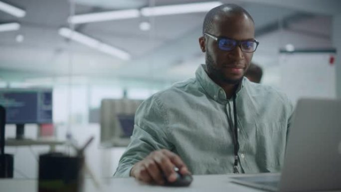现代办公室: 在笔记本电脑上工作的有动力的黑人IT程序员的肖像。男性专家创建网站，软件工程师开发应用