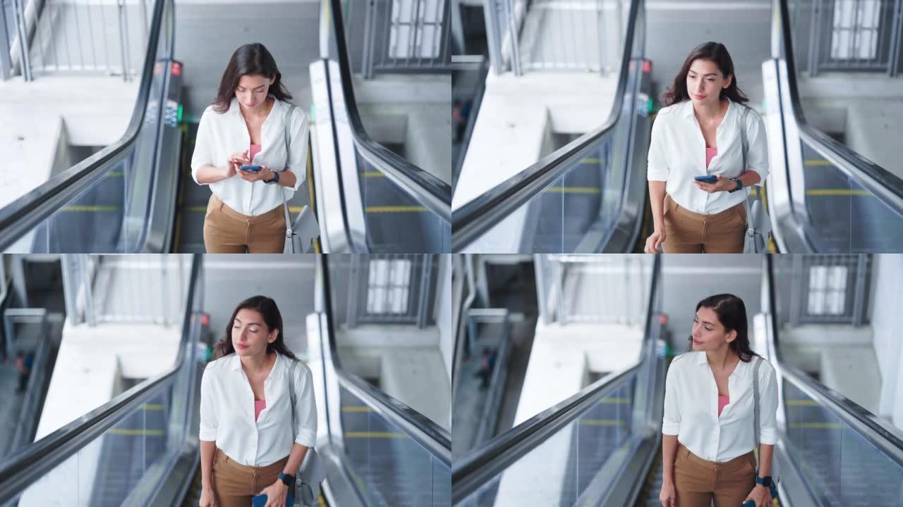 在自动扶梯上使用智能手机的女人