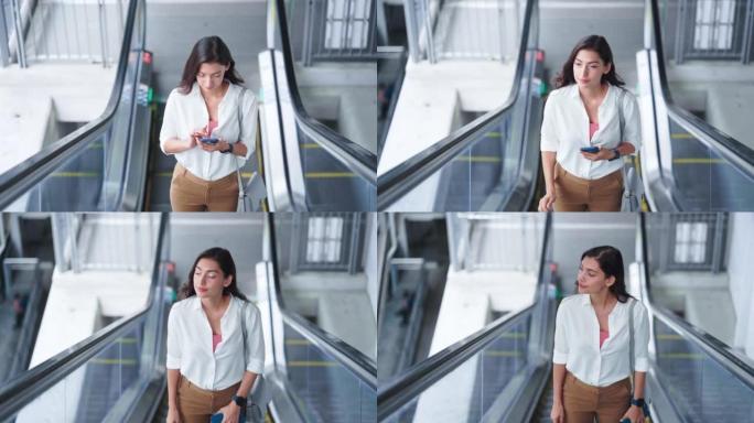 在自动扶梯上使用智能手机的女人