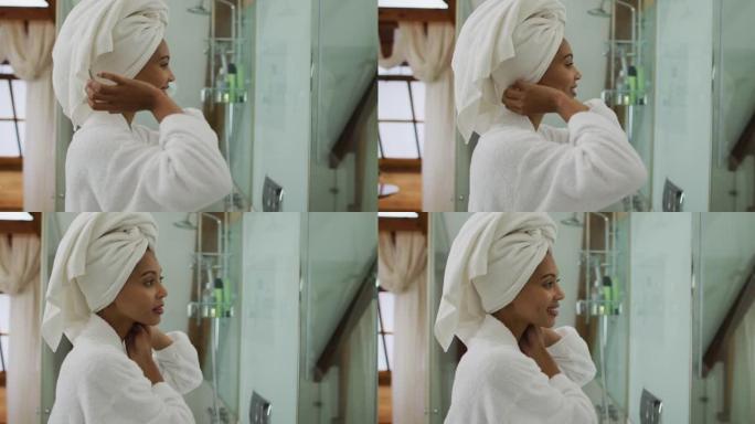 混血女人穿着浴袍看着镜子