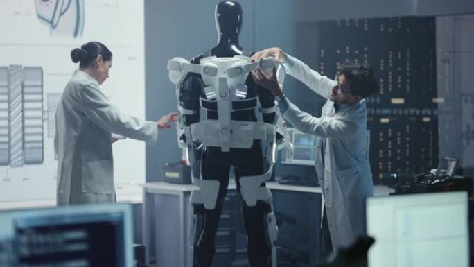 在机器人技术开发实验室: 首席女工程师和顶级男科学家在仿生外骨骼原型上工作。设计动力外衣以帮助残疾人