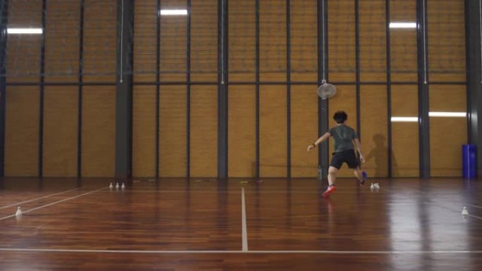 广角亚洲华裔羽毛球选手在羽毛球场练习耐力训练