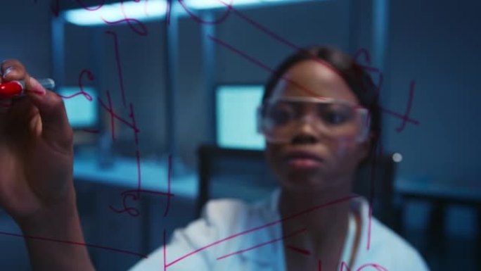 一位严肃的黑皮肤女科学家的特写镜头，在实验室的玻璃板上解决了化学反应