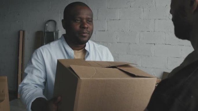 男性黑人房主从搬家公司接收箱子